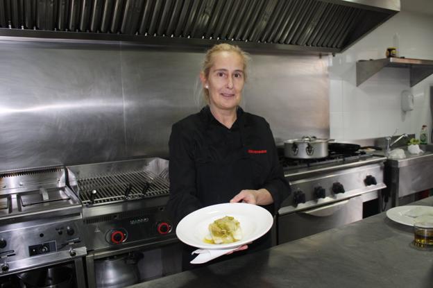 María Teresa Fernández-Bobadilla, con el plato de bacalao, en la cocina de su restaurante. :: /Félix Domínguez