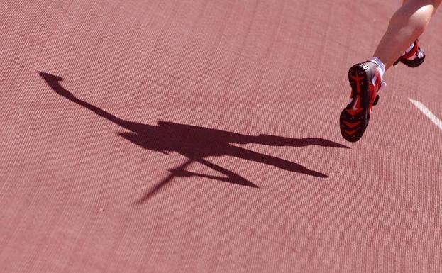 La sombra de un lanzador de jabalina se refleja en la pista.