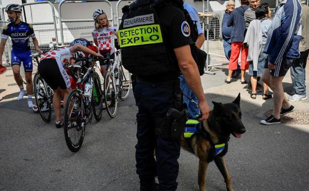 Un policía, acompañado de un perro detector de explosivos, vigila durante la tercera etapa.