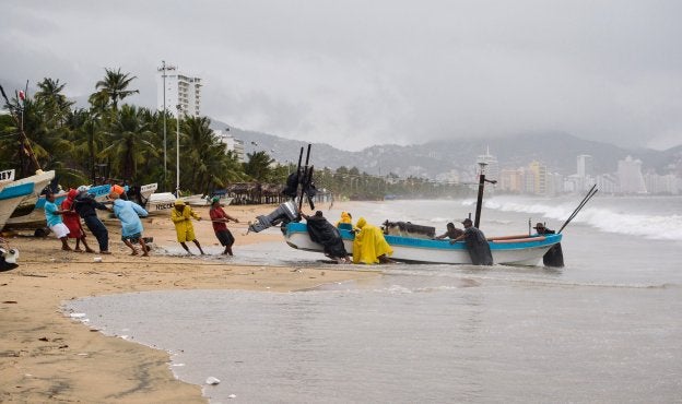 Pescadores sacaban el jueves sus embarcaciones del mar ante la llegada del huracán 'Max' a Acapulco. :: F. Robles / afp