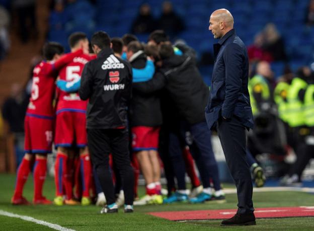 Zidane, con cara de circunstancias, mientras los jugadores del Numancia celebran el segundo gol del partido en el Bernabéu. :: efe
/