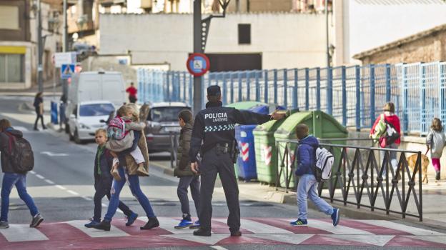 Un policía local facilita el paso de los peatones a la salida del colegio González Gallarza de Lardero. :: justo rodríguez/