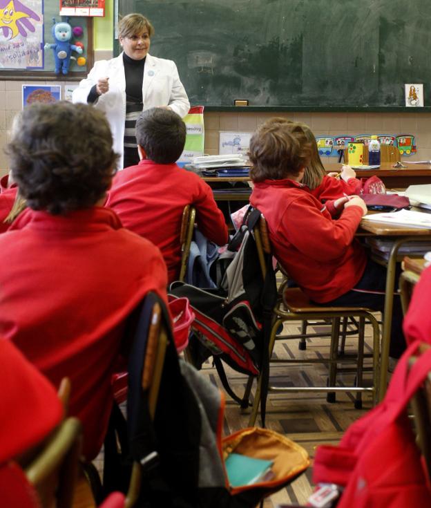 Una maestra da clase en un aula de Primaria de un colegio español. :: AFP/