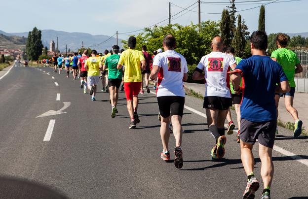 Los atletas afrontan los primeros metros de la carrera por el asfalto de la LR-255. :: F.D./
