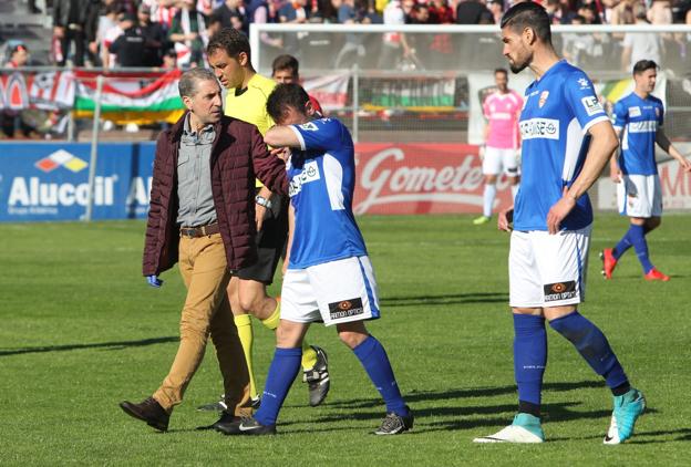 Antxon Muneta se retira del campo acompañado por el doctor Vicente Elías. :: fernando díaz/