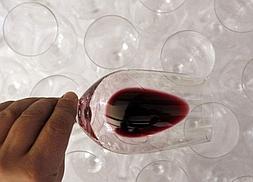 Un hombre comprueba el color y el cuerpo de un vino tinto. / REUTERS/