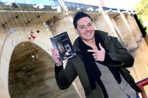 El logroñés Israel Esteban posa frente al puente de Piedra, donde ha colgado varios muñecos y peluches para promocionar su libro. :: JUAN MARÍN/