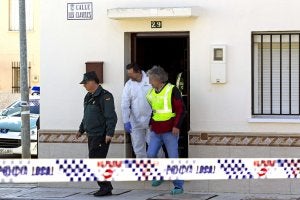 Tres agentes abandonan la casa donde se hallaron los cuerpos. ::
EFE/
