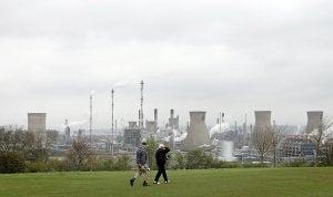 Dos jugadores de golf caminan frente a la refinería de petróleo en Grangemouth. ::
PAUL ELLIS / AFP/