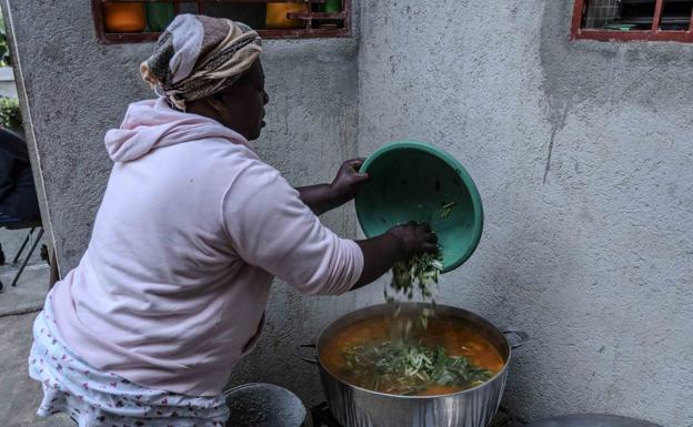 Una mujer haitiana cocina la sopa 'joumou'. / EFE